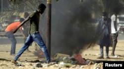 FILE - Sudanese demonstrators light a fire as they participate in anti-government protests in Khartoum, Sudan, Jan. 25, 2019.