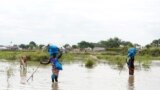 Women carry belongings on their heads as they wade through water, after heavy rains and floods forced hundreds of thousands of people to leave their homes, in the town of Pibor, Boma state, South Sudan, Nov. 6, 2019.