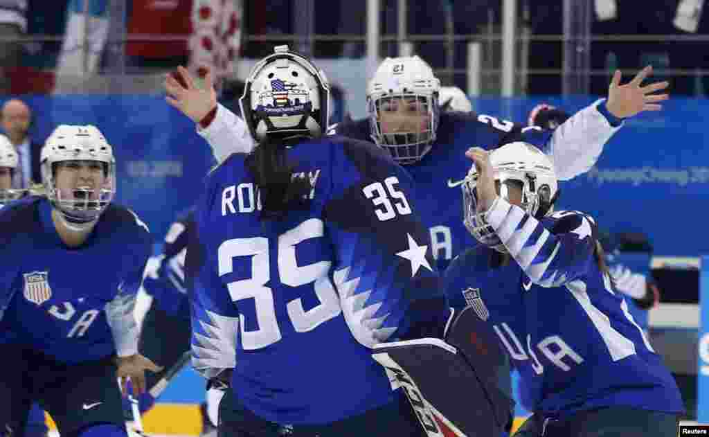 U.S. players celebrate with teammate and goalie Maddie Rooney after she made the winning save in the women's gold medal hockey game in Gangneung, South Korea, Feb. 22, 2018.