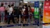 FILE - An airliner worker asks travelers to declare their health information after checking in at the international flight check in counter at the Beijing Capital International Airport in Beijing, Aug. 24, 2022. 