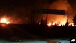 FILE - This photo released May 9, 2018, by the Syrian official news agency SANA, shows flames rising after an attack in an area known to have numerous Syrian army military bases, in Kisweh, south of Damascus, Syria.