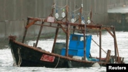 A wooden boat, which according to a police official carried eight men who said they were from North Korea and appear to be fishermen whose vessel ran into trouble, is seen near a breakwater in Yurihonjo, Akita Prefecture, Japan, Nov. 24, 2017. (Kyodo/via 