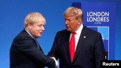 FILE - Britain's Prime Minister Boris Johnson shakes hands with U.S. President Donald Trump during a welcoming ceremony at the NATO leaders summit in Watford, Britain, Dec. 4, 2019. 