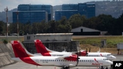 Aircraft from the Avianca airline sit parked at La Aurora airport in Guatemala City, Tuesday, March 17, 2020. 