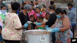 جنوبی افریقہ کے قصبے کیپ ٹاؤن میں بچے کرونا وائرس کے لاک ڈاؤن کے دوران خوراک حاصل کرنے کے لیے قطار میں کھڑے ہیں۔ 21 اپریل 2020
