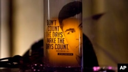 FILE - A candle is lit at a makeshift memorial to Muhammad Ali at the Muhammad Ali Center, in Louisville, Kentucky, June 9, 2016. For one week following his death last spring not a single person died of gunfire in the boxing great's hometown. But the peace was short-lived.