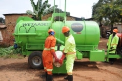 Kampala Capital City Authority workers empty latrines in Makindye Lukuli, Uganda, July 10, 2019.