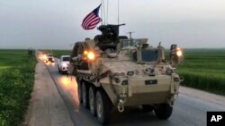 This Friday, April 28, 2017 still taken from video, shows U.S. forces patrolling on a rural road in the village of Darbasiyah, in northern Syria. 