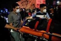 Rescuers transport an injured person on a stretcher at a site where an overpass for a metro partially collapsed with train cars on it at Olivos station in Mexico City, Mexico, May 3, 2021.