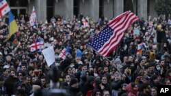 Протестувальники біля будівлі парламенту Грузії в Тбілісі, Грузія, 8 березня 2023 року. Тисячі людей збиралися протягом кількох днів у Тбілісі, щоб протестувати проти закону, що віддаляв Грузію від вступу до ЄС і НАТО. Фото AP/Зураб Церцвадзе.