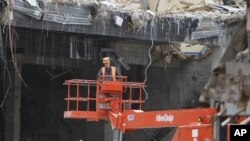 A workman operates a mobile crane at the site of a demolished building in central Christchurch, New Zealand, as the clean up from the February 11 earthquake takes place (File Photo - September 7, 2011).