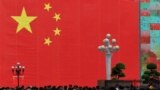 People walk in front of a giant Chinese flag at a central business district ahead of the 70th founding anniversary of People's Republic China in Chongqing, China, Sept. 13, 2019. (Chen Chao/CNS via Reuters)