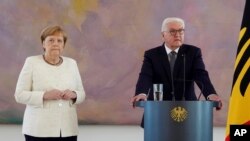 La canciller de Alemania, Angela Merkel, junto al presidente Frank-Walter Steinmeier, durante un evento por el nombramiento y despedida de funcionarios. Berlín, junio 27 de 2019.