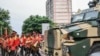 The Mozambican Presidential Military band walk next to an armoured Police vehicle near Parliament in Maputo on Jan. 13, 2025. Mozambique is set to swear in its new parliament on Jan. 13, 2025, following months of deadly protests over an election in October.