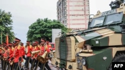 The Mozambican Presidential Military band walk next to an armoured Police vehicle near Parliament in Maputo on Jan. 13, 2025. Mozambique is set to swear in its new parliament on Jan. 13, 2025, following months of deadly protests over an election in October.