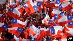 Aficionados del equipo nacional de fútbol de Chile agitan banderas de la nación antes de la final de la Copa América entre Chile y Argentina en julio 4 de 2015. La FIFA sancionó a Chile y otros países por la conducta antideportiva de sus aficionados.