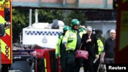 An injured woman is led away after an incident at Parsons Green underground station in London, Britain, Sept. 15, 2017. 