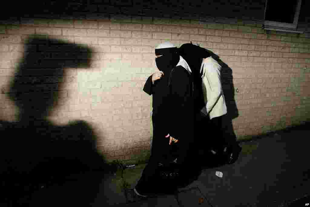 دو زن مسلمان در شهر بلکبرن بریتانیا از مرکز جامعه لیتل هاروود خارج می شوند. نخست وزیر بریتانیا تلویحا روز دوشنبه به بی بی سی گفت زنان مهاجر مسلمانی که انگلیسی بلند نباشند، ممکن است از بریتانیا دیپورت شوند.
