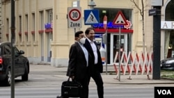 Two unidentified members of an Iranian delegation walk in Vienna on April 5, 2021 as they prepare for talks the next day aimed at reviving the 2015 Iran nuclear deal. (VOA Persian/Guita Aryan)