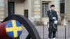 ARCHIVO - Un soldado sueco hace guardia junto a un cañón ceremonial en el patio del Palacio Real de Estocolmo, Suecia, el 25 de febrero de 2024.