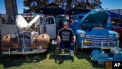 FILE - Santos Gonzalez duduk di antara mobil antik Chevy tahun 1939 dan 1949 pada pameran lowrider (mobil ceper) memperingati ulang tahun ke-20 Lincoln Park di El Paso, Texas, 22 September 2024. (Andrés Leighton/AP)