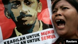 Seorang pengunjuk rasa meneriakkan slogan sambil mengacungkan poster aktivis HAM, Munir Said Thalib, dalam demonstrasi di luar kantor Badan Intelijen Nasional (BIN), di Jakarta, 7 September 2007. 