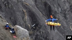 Seorang petugas penyelamatan diangkat ke dalam helikopter di lokasi jatuhnya pesawat dekat Seyne-les-Alpes, Perancis (26/3). (AP/Laurent Cipriani)