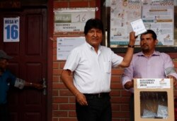 Bolivia's President Evo Morales, left, poses for a picture before casting his vote in Villa 14 de Septiembre, in the Chapare region, Bolivia, Oct. 20, 2019.