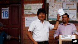 Bolivia's President Evo Morales, left, poses for a picture before casting his vote in Villa 14 de Septiembre, in the Chapare region, Bolivia, Oct. 20, 2019. 