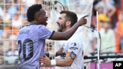 FILE: Real Madrid's Vinicius Junior, left, confronts Valencia fans in front of Valencia's Jose Luis Gaya during a match between Valencia and Real Madrid, in Valencia, on May 21, 2023. The game was temporarily stopped when Vinicius said a fan had insulted him from the stands.