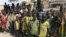 FILE - Children look at WFP food trucks arriving on February 13, 2016 in Pierri village of Jonglei State for the first time in three years since fighting broke out in December 2013 forcing locals here to survive on wild plants, trees and leaves.