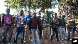 In this Aug. 28, 2014, photo an Anti-Balaka group that defends the Christian neighborhood near the Church of the city stands for a photo in Boda, Central African Republic. More than 5,000 people have died in sectarian violence in the Central African Republic since December, according to an Associated Press tally. (AP Photo/Sylvain Cherkaoui)