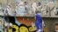 An Egyptian woman passes by a wall with defaced posters of presidential candidates in Cairo, Egypt, Monday, May, 21, 2012.