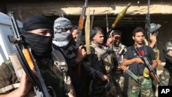 Iraqi Shi'ite Turkmen gunmen gather as they prepare to patrol around the village of Taza Khormato in the northern oil rich province of Kirkuk, June 20, 2014.