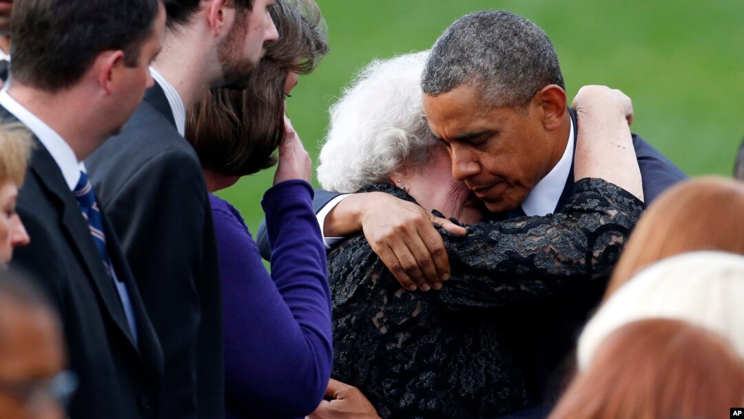 El presidente Barack Obama consuela a una mujer no identificada en la sección de las familias de las víctimas de la matanza del Astillero Naval.