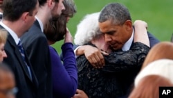 El presidente Barack Obama consuela a una mujer no identificada en la sección de las familias de las víctimas de la matanza del Astillero Naval.