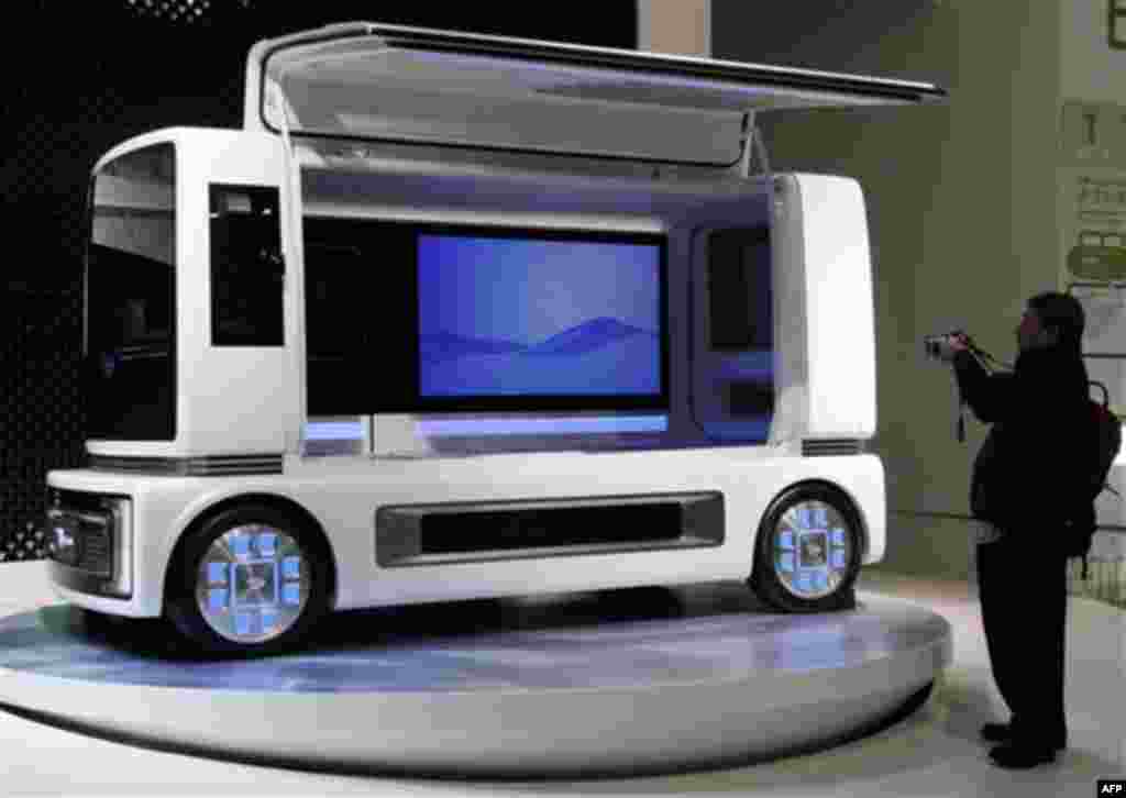 A visitor snaps Daihatsu Motor Co., concept car "FC SHO CASE" on displays during the Tokyo Motor Show in Tokyo, Wednesday, Nov. 30, 2011. (AP Photo/Koji Sasahara)