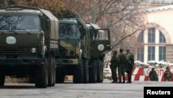 Personal militar armado junto a camiones sin marca en Donetsk, al este de Ucrania.