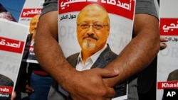 Para pengunjuk rasa memegang potret Jamal Khashoggi, jurnalis Saudi yang terbunuh di dekat konsulat Arab Saudi di Istanbul, pada peringatan dua
tahun kematiannya, 2 Oktober 2020. (AP/Emrah Gurel)