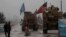 A line of US military vehicles drive through a checkpoint of the Internal Security Forces in Manbij as they head to their base on the outskirts of the northern Syrian city on December 30, 2018.