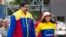 Venezuela's President Nicolas Maduro and first lady Cilia Flores jump during the closing campaign rally in Caracas, Venezuela, Dec. 3, 2015. 