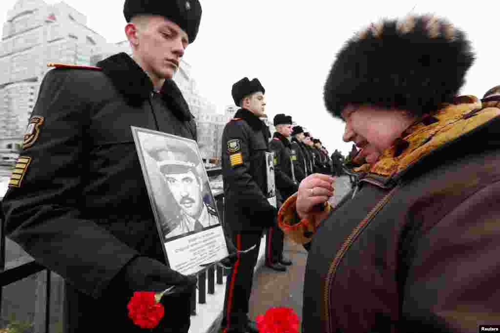 Svetlana Khodak, 66, looks at a portrait of her husband Victor, killed in Afghanistan, during a wreath-laying ceremony near a monument commemorating the Soviet victims of the war in Afghanistan, in Minsk, Belarus.