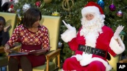 Santa Claus gestures toward first lady Michelle Obama, at Children's National Medical Center in Washington