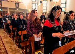 FILE - Iraqi Catholics pray during Mass at Mar Youssif Chaldean church, in Baghdad, Iraq, Dec. 25, 2018.