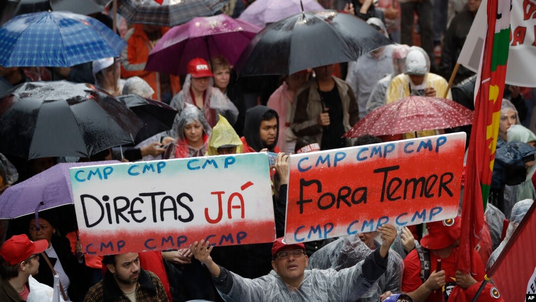 Demonstrators march against Brazil's President Michel Temer, holding banners that reads in Portuguese "Temer Out", and "Elections Now", in Sao Paulo, Brazil, May 21, 2017.
