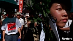 A protester wearing a T-shirt depicting Tiananmen's "Tankman" join hundreds of others in taking part in a march in Hong Kong, three days before the 25th anniversary of the military crackdown on the pro-democracy movement at Beijing's Tiananmen Square in 1989, June 1, 2014.