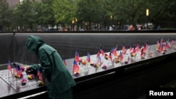 Una persona coloca unas flores frente al monumento en honor a las víctimas del 11 de septiembre de 2001 en el World Trade Center de Nueva York, en vísperas del aniversario 22, el 10 de septiembre de 2023.