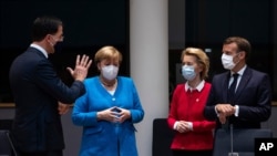 From left, Dutch Prime Minister Mark Rutte, German Chancellor Angela Merkel, European Commission President Ursula von der Leyen and French President Emmanuel Macron speak during a meeting on the sidelines of an EU summit in Brussels, July 18, 2020.