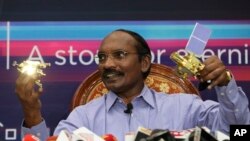 Indian Space Research Organization (ISRO) Chairman Kailasavadivoo Sivan displays a model of Chanrayaan 2 orbiter and rover during a press conference at their headquarters in Bangalore, India, Aug. 20, 2019.