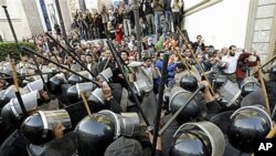 Egyptian anti-riot police confront Egyptian activists outside a journalists syndicate in downtown Cairo, Egypt, January 26, 2011